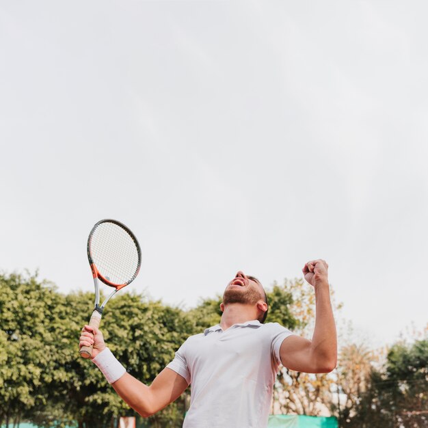 Athletic young boy winning a tennis game