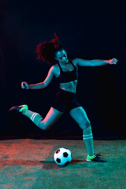 Free photo athletic young girl kicking ball