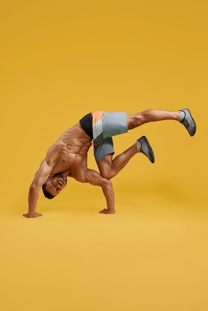 Athletic young man doing handstand exercise