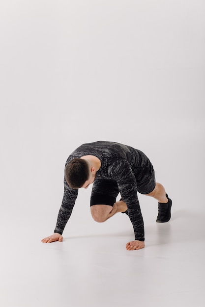 Athletic young man doing workouts at home, man doing training, warm up before weight exercise.