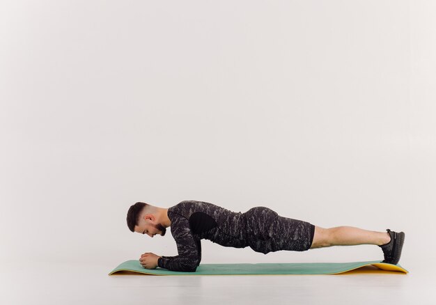 Athletic young man doing workouts at home, man doing training, warm up before weight exercise.