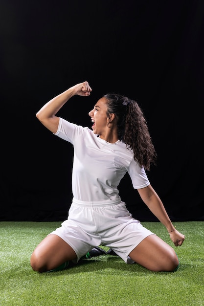 Athletic young woman on football pitch