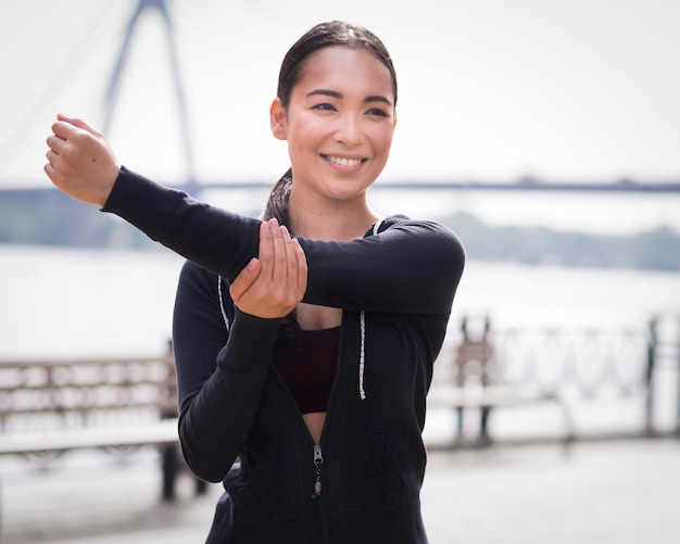 屋外ストレッチ運動の若い女性