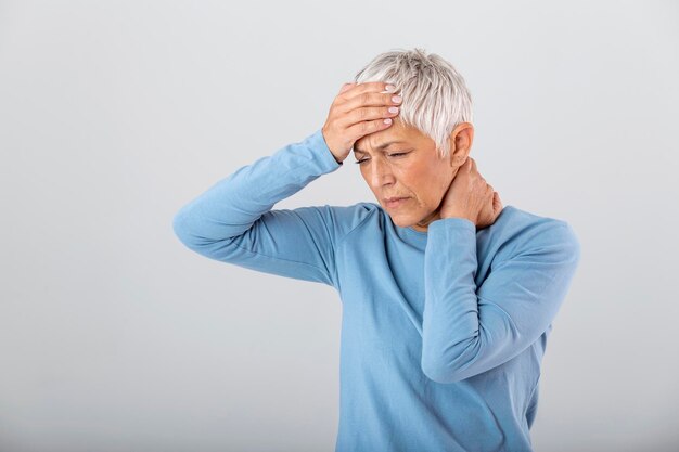 Attack of the monster migraine Sinus pain Unhappy Retired Senior Woman holding her head with pain expression Face of senior woman suffering from headache