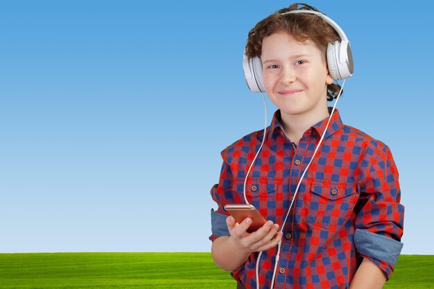 Attracive kid is listening music with headphones