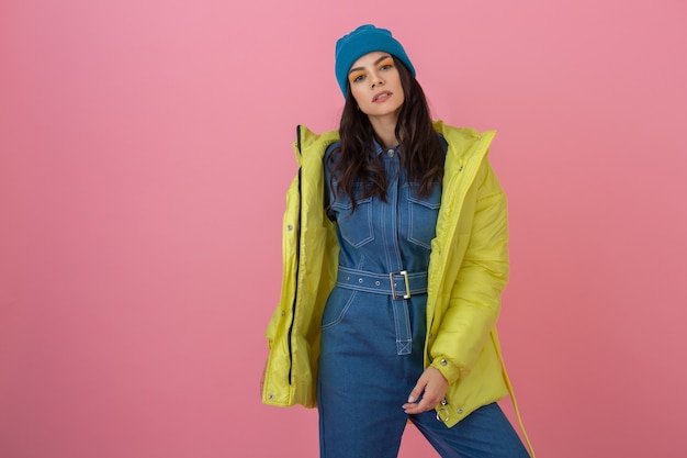 Foto gratuita modello di donna attiva attraente in posa sulla parete rosa in piumino invernale colorato di colore giallo brillante, tendenza moda cappotto caldo