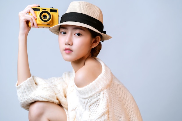 Attractive beautiful asian female casual dress wear hat hand hold film camera travel vacation concept white background