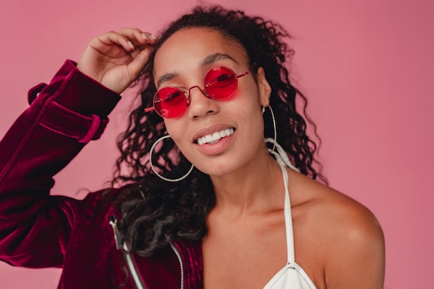 Attractive black african american woman in stylish outfit on pink background