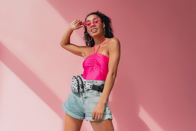 Attractive black african american woman in stylish outfit on pink background