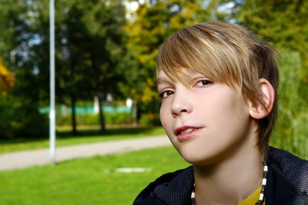 Ragazzo biondo attraente che posa nel parco