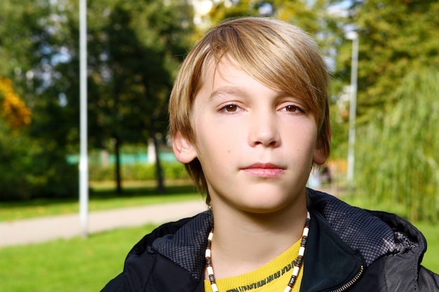 Ragazzo biondo attraente che posa nel parco