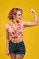 Free photo attractive blonde girl raising hand and showing biceps