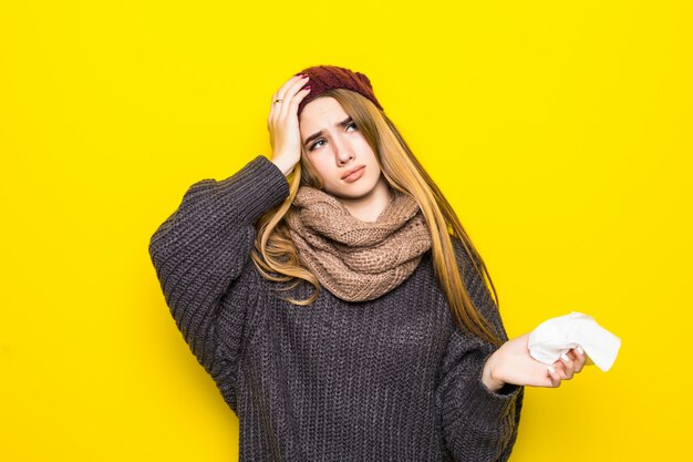 Привлекательная блондинка в теплом свитере страдает головной болью и пытается согреться
