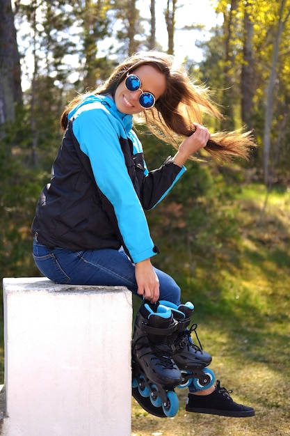 An attractive brunette female wearing roller skates.