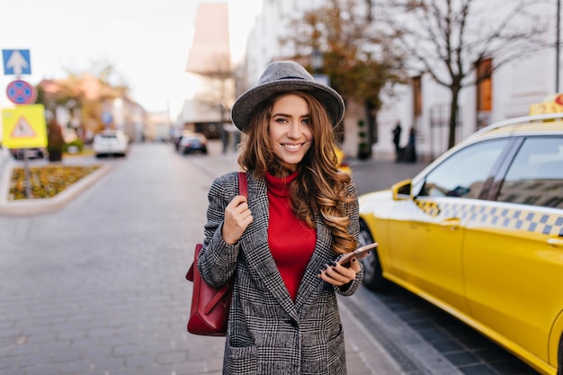 Foto gratuita signora attraente di affari che affretta ad ufficio nella calda giornata autunnale