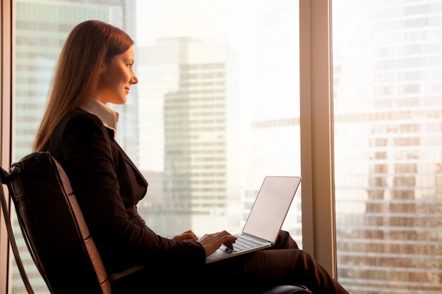 Attractive businesswoman enjoying sunset, relaxing in office cha