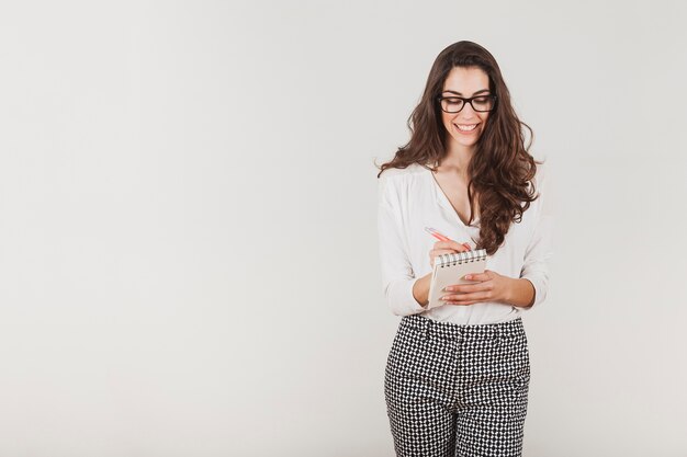 Attractive businesswoman with glasses writing