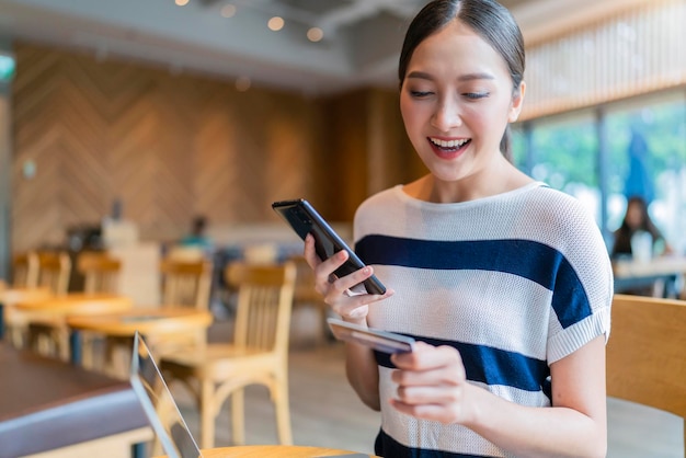 Привлекательная повседневная умная азиатская женщина делает покупки онлайн с данными кредитной карты и образом жизни ноутбука