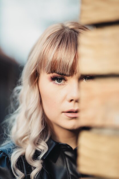 Attractive Caucasian blonde female wearing a stylish leather dress posing for a fashion photoshoot