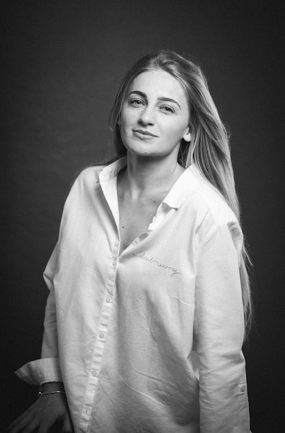 Free photo an attractive caucasian blonde female in a white shirt posing on a brown