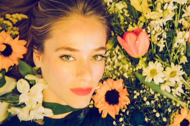 Foto gratuita attraente donna affascinante tra fiori freschi