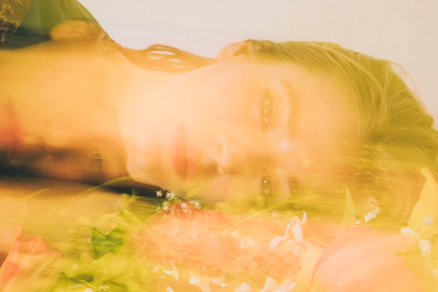Бесплатное фото Привлекательная очаровательная женщина, лежа с букетом цветов