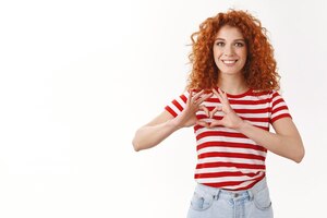 attractive cheerful glad redhead curlyhaired female volunteer trying safe animals wildlife spread love care show heart sign chest smiling broadly feel optimistic express sympathy affection