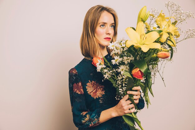 Attractive confident woman with big bouquet of blooms