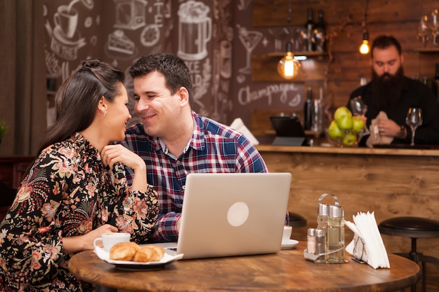 Привлекательная пара на деловой встрече в ресторане обсуждает рабочие моменты в обеденное время. Хипстерский паб.