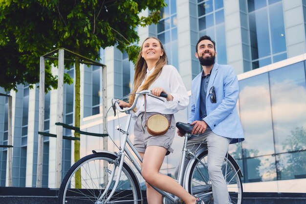 街で自転車に乗った後のデートで魅力的なカップル。