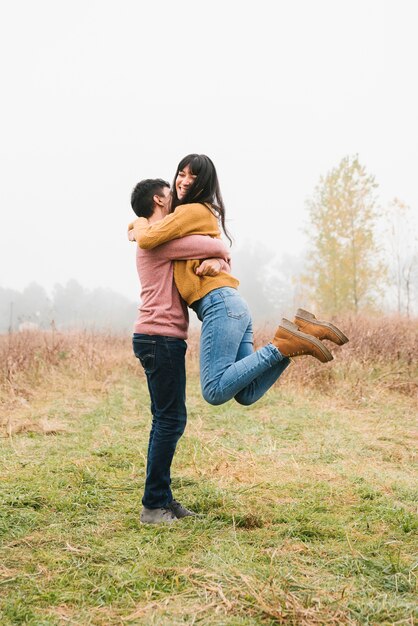 Attractive couple hugging on meadow 