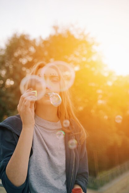 Attractive cute teenage girl make soap bubbles