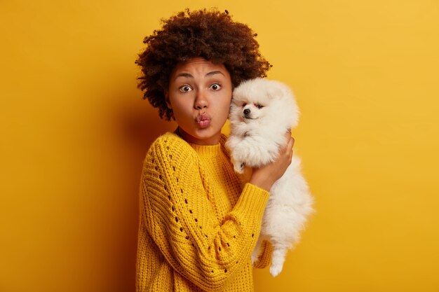 Attractive dark skinned woman adores her cute pet