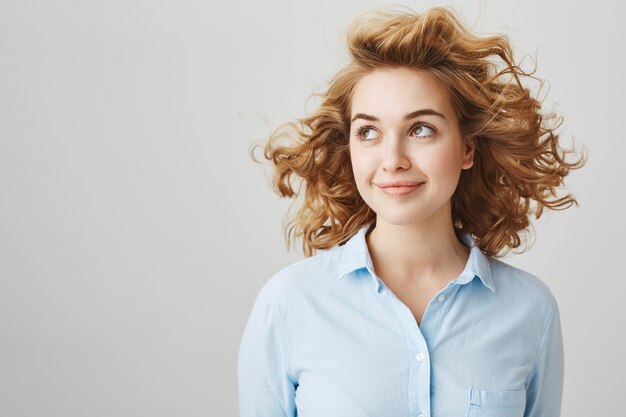 Attractive dreamy girl looking left and smiling, beauty and hairstyle concept