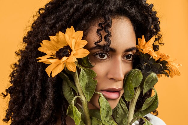 Attractive ethnic thinking woman with flowers