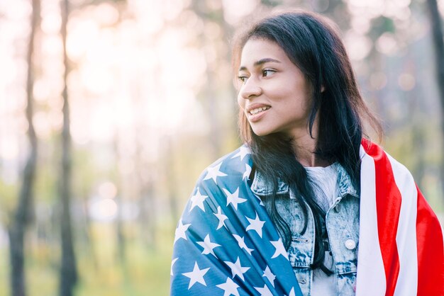魅力的な民族女性がアメリカの国旗とポーズ
