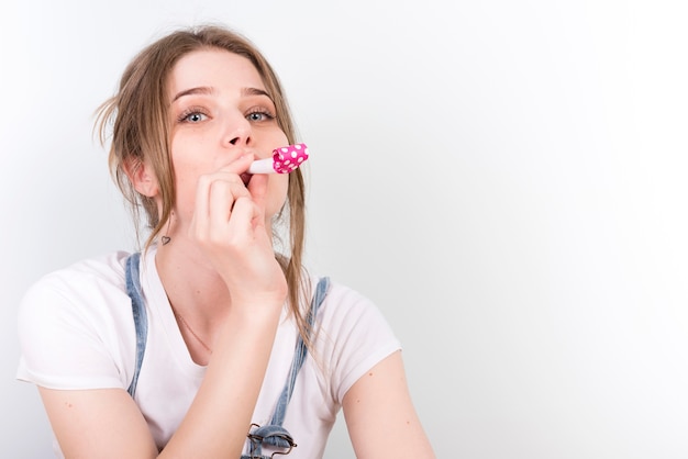 Attractive female blowing bright whistle