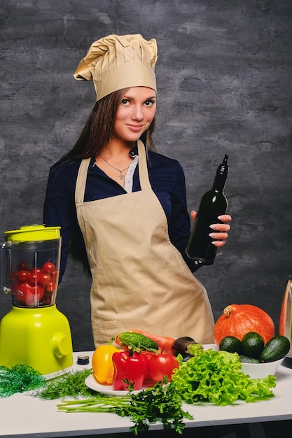 Attractive female chef cook holds bottle with oil.