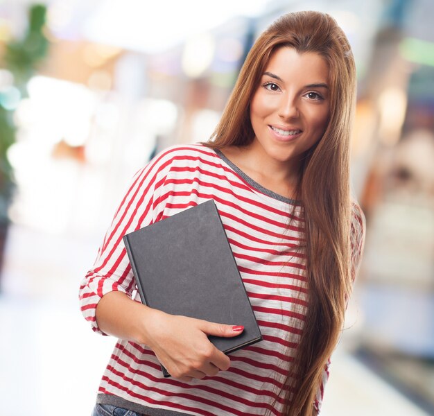 Attractive female student holding notebook