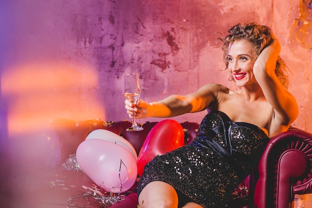 Attractive festive woman sitting on sofa