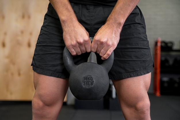 Attractive fit man working out indoors with dumbbells