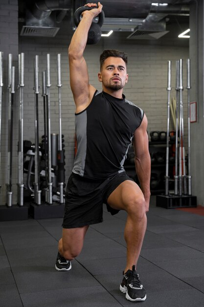 Attractive fit man working out indoors with dumbbells