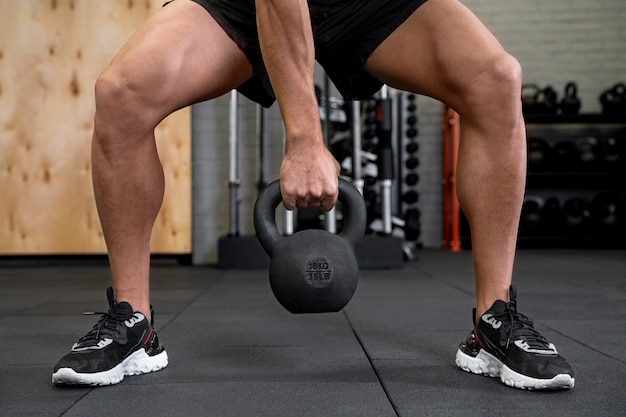 Attractive fit man working out indoors with dumbbells