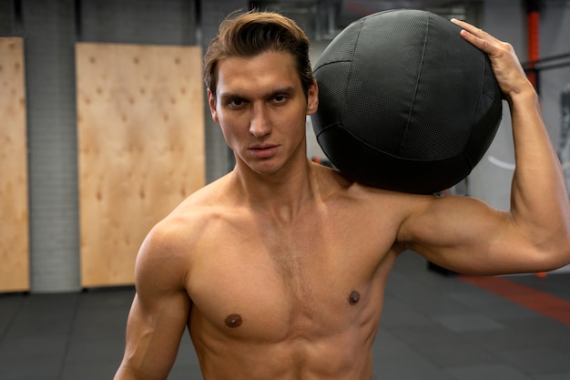 Free photo attractive fit man working out indoors with exercise ball