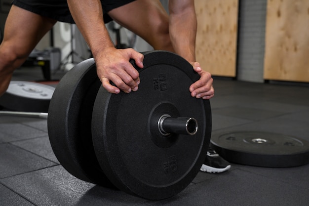 Free photo attractive fit man working out indoors with weights