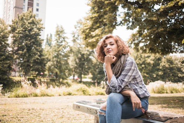 Foto gratuita attraente zenzero femmina sulla panchina nel parco