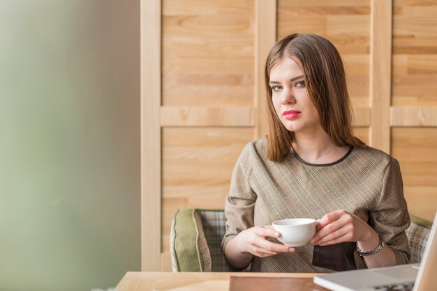 Attractive girl holding a white cup