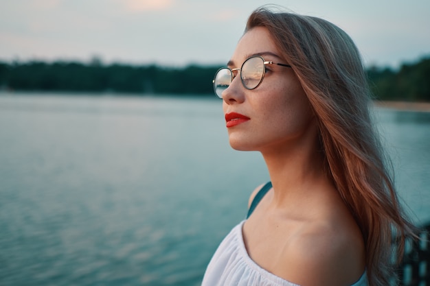 Привлекательная девушка в очках на парк вид на озеро
