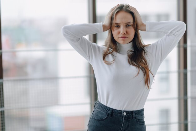 Attractive girl on the window shows different emotions and mood.