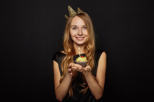 Attractive girl with a crown and cupcake